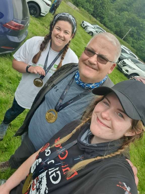 Man and two ladies showing medals.