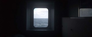 Looking out at sea from a portal in a cabin