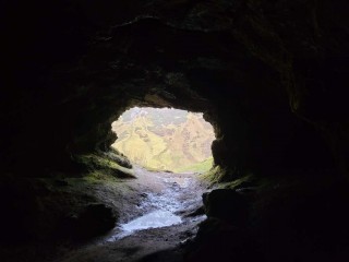 Looking out at mountains from inside a cave.
