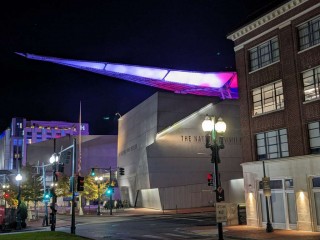Canopy of Peace lit up at night on top of the National WWII Museum