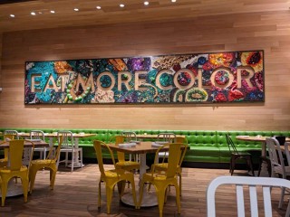 A sign on the wall in True Food Kitchen that says Eat More Color